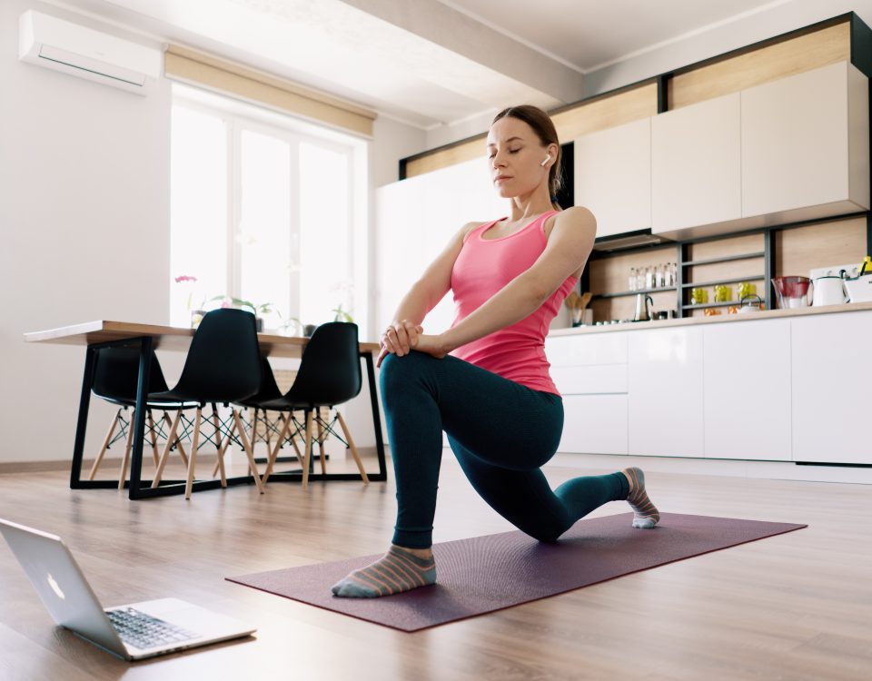 Mulher se exercitando em casa, olhando treino no computador