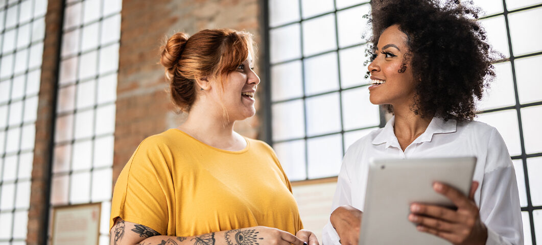 Mulheres alinhando expectativa no trabalho para aumento de bem-estar.