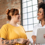 Mulheres alinhando expectativa no trabalho para aumento de bem-estar.