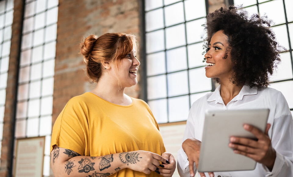 Mulheres alinhando expectativa no trabalho para aumento de bem-estar.