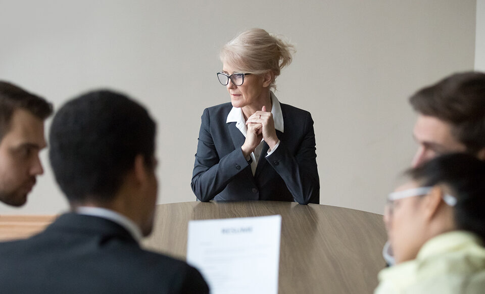 pessoas sentadas na mesa debatendo etarismo